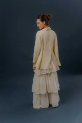 Chaqueta de lino color beige, de calce relajado, con escote en V, cierre frontal con botones y bolsillos frontales aplicados.
