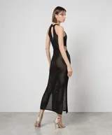 Vestido largo negro calado de malla con lunares brillantes, cuello halter, cortes en los laterales, aberturas laterales y forro.