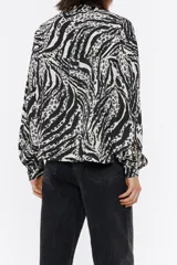 Camisa corta de pana con estampado de cebra y leopardo. Modelo de corte boxy, cuello con tira, manga larga con puño y botones de presión, cierre frontal con botonadura de presión y bolsillo de plastrón en el pecho.