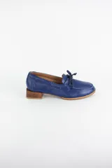 Mocasín náutico de cuero azul, con detalle de cordones en el empeine y taco cuadrado bajo simil madera.