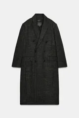 Abrigo largo de mujer, color gris oscuro jaspeado, con cuello solapa de muescas, manga larga y cierre cruzado con botones frontales. Presenta bolsillos con solapa en el delantero y aberturas en el bajo.