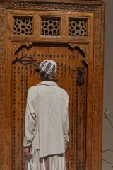 Camisa de lino negra con bordados dorados en forma de árbol o palmera estilizada. Presenta cuello camisero, botones frontales dorados y pliegues verticales en la parte inferior delantera.