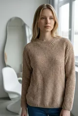 Sweater de tejido de punto con textura tipo waffle, color crudo, de corte clásico con cuello redondo y mangas largas con puños acanalados.