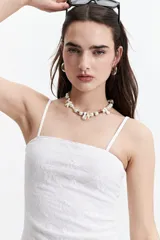 Top blanco de encaje con escote recto y breteles finos.