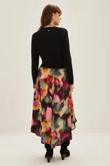 Falda midi de viscosa con estampado abstracto multicolor en tonos vibrantes como fucsia, violeta, verde y naranja. Presenta un diseño fluido con una abertura frontal que permite mayor movimiento.