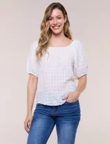 Blusa blanca de tela texturada y silueta fluida, con escote en U y frunces. Cuenta con mangas cortas abullonadas con elástico en los puños y ruedo redondeado.