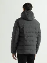 Campera acolchada con capucha integrada y cuello alto. Presenta cierre frontal completo, bolsillos laterales con cierre y puños con terminaciones elásticas para mayor protección contra el frío.