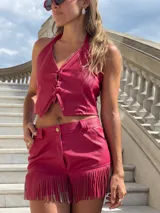 Short de cuero sintético color fucsia con flecos en el ruedo.