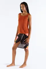 Musculosa tejida en punto canalé con mezcla de viscosa y hilos metálicos Lurex color naranja, con escote bote y sin mangas.