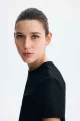 Remera de algodón negro con cuello redondo y mangas cortas.