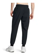 Joggers deportivos Under Armour modelo Unstoppable, confeccionados en tejido técnico elástico con tecnología UA Storm repelente al agua. Presentan corte ajustado en las piernas, cintura elástica con cordón interno, bragueta funcional con cierre a presión, bolsillos laterales y bolsillo trasero con cremallera sellada.