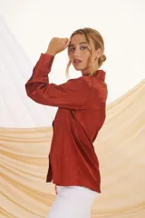 Camisa beige con estampado de líneas diagonales, cuello clásico, cierre con botones y mangas largas con puños abotonados.