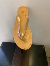 Ojotas de cuero color suela con tiras finas doradas.