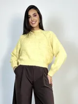 Sweater de punto con diseño amplio y mangas ranglan. Presenta cuello redondo tejido y puños acanalados, ofreciendo un calce cómodo y versátil.