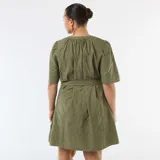 Vestido corto verde militar con bordado inglés, escote en V con botones frontales, mangas cortas y lazo ajustable en la cintura.