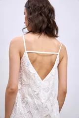 Vestido corto blanco de broderie con breteles finos y corte recto.