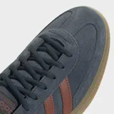 Zapatillas Adidas Handball Spezial, color azul con detalles en marrón. Capellada de gamuza, con las tres tiras clásicas de Adidas en los laterales y suela de goma color caramelo.