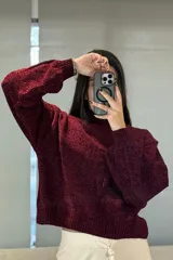 Buzo de chenille color marrón, con cuello alto, mangas largas con puños ajustados y ruedo acanalado.