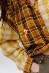 Camisa de algodón con diseño de patchwork a cuadros en tonos tierra, con cuello mao, cierre frontal de botones y detalles de apliques bordados.