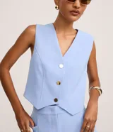 Chaleco slim color marrón, confeccionado en crepé, con escote en V y cierre frontal de botones metálicos.
