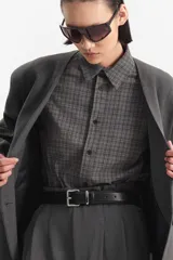 Camisa de cuello con botones, manga larga y silueta amplia, confeccionada en tejido de cuadrillé gris.