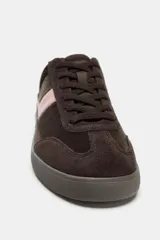 Zapatillas deportivas de estilo urbano, confeccionadas en una combinación de gamuza marrón oscuro y detalles en cuero rosado en el lateral y el talón. Presentan cierre mediante cordones al tono y suela de goma plana.
