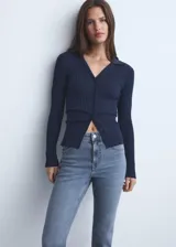 Jeans de tiro medio con diseño flare y bajo deshilachado, con cinco bolsillos, presillas para cinturón y cierre frontal con cremallera y botón.