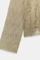 Jersey de punto con hilo metalizado, cuello redondo y manga larga, de diseño ligero y semitransparente.