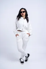 Conjunto deportivo compuesto por una campera corta con cierre frontal y un pantalón tipo jogging, ambos en color blanco.