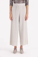 Pantalon tipo palazzo de corte amplio y tiro alto, confeccionado en tejido plisado con acabado brillante.