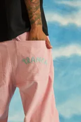 Pantalón celeste de corderoy con corte recto, bolsillos laterales y traseros, cierre frontal YKK con botón y bordado rosa con la palabra "Tranca" en el bolsillo trasero.