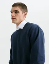 Sweater básico de cuello redondo y manga larga, confeccionado en tejido circular con puños y cuello en tejido canalé.