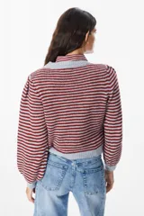 Sweater de punto con diseño de rayas horizontales en color bordó y gris, con mangas abullonadas y cuello redondo. Incluye un detalle de cuello de camisa a rayas incorporado con lazo frontal.