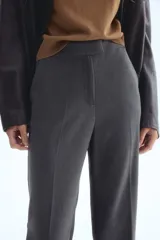 Pantalón de vestir color gris oscuro con corte bootcut. Presenta pretina prolongada con cierre oculto, bolsillos laterales al bies y bolsillos traseros ribeteados. Diseño con raya marcada adelante y atrás.