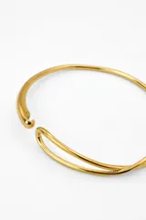 Pulsera rígida dorada con cierre tipo gancho.