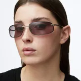 Lentes de sol estilo envolvente con montura metálica plateada y cristales rectangulares de bordes redondeados con efecto degradado.