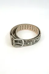 Cinturón de cuero sintético dorado con apliques de tachas y strass plateados, hebilla metálica plateada.