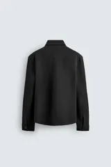 Sobrecamisa de corte regular fit en tejido elástico y transpirable, con cuello solapa, cierre frontal mediante botones a presión y bolsillo de plastrón en el pecho. Presenta mangas largas con puños abotonados y bajo con aberturas laterales.