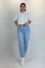 Jean mom fit de color celeste claro, tiro alto, con cinco bolsillos y cierre frontal con botón y cremallera.