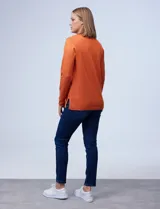 Buzo rojo tejido en hilado fino con escote en V y pespunte central.