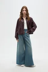 Chaqueta de eco-cuero color marrón oscuro, con cuello camisero, cierre frontal con botones, mangas largas abullonadas con puños y detalles de frunces en los hombros.