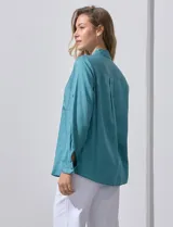 Camisa color verde oliva de lyocell, marca Cyrus. Tiene cuello con solapa, abertura central con botones, mangas 3/4 regulables con presilla y botón, y dos bolsillos delanteros aplicados.