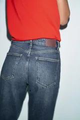 Jeans de tiro alto con corte mom fit, cinco bolsillos y cierre frontal con cremallera y botón.