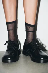 Zapato tipo blucher de estilo clásico con cierre mediante cordones. Presenta un acabado en punta redonda y suela con plataforma.