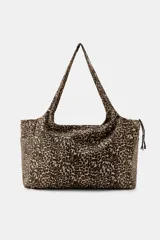 Maxi bolsa de algodón con estampado animal print de leopardo, diseño rectangular con asas de hombro, bolsillos en los laterales y cierre de cremallera con tiras trenzadas.