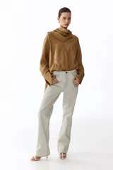 Blusa oversized de lyocell en color tostado, con cuello pañuelo drapeado y mangas largas raglán con puños anchos.