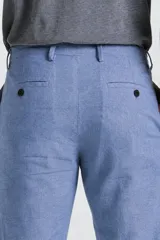 Pantalón de lino celeste de corte slim, con trabillas para cinturón y bolsillos laterales.