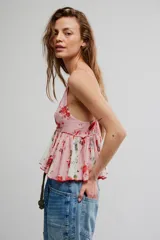 Top estilo babydoll de viscosa color rosado con estampado floreado, escote en V pronunciado, tirantes finos y detalles de volados combinados con paneles en tono crudo.