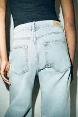 Jeans de tiro bajo con cinco bolsillos, pernera recta y detalle de costuras marcadas en la parte delantera. Cierre frontal con cremallera y botón.