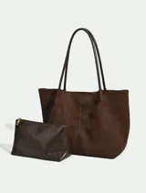 Bolso tipo tote de diseño minimalista en color negro, con textura suave y doble asa larga para llevar al hombro.